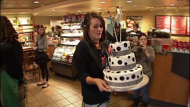 A woman carefully handles the wedding cake Tuesday.