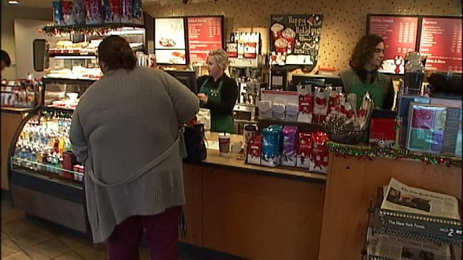 Starbucks employee Sara Penn serves a customer Tuesday.